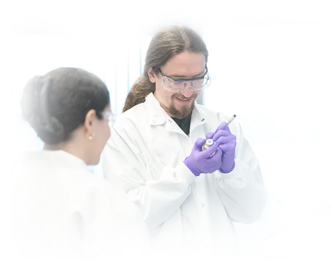 Two Mariana Oncology scientists smiling as they collaborate in the lab