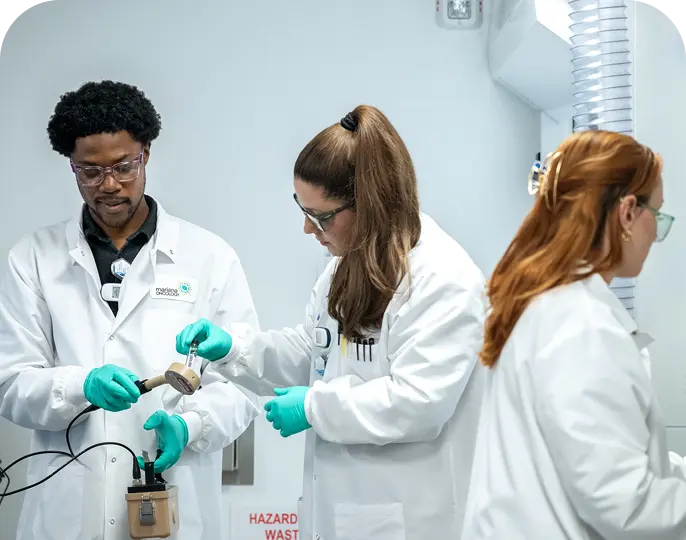 Three Mariana Oncology scientists collaborating in the lab