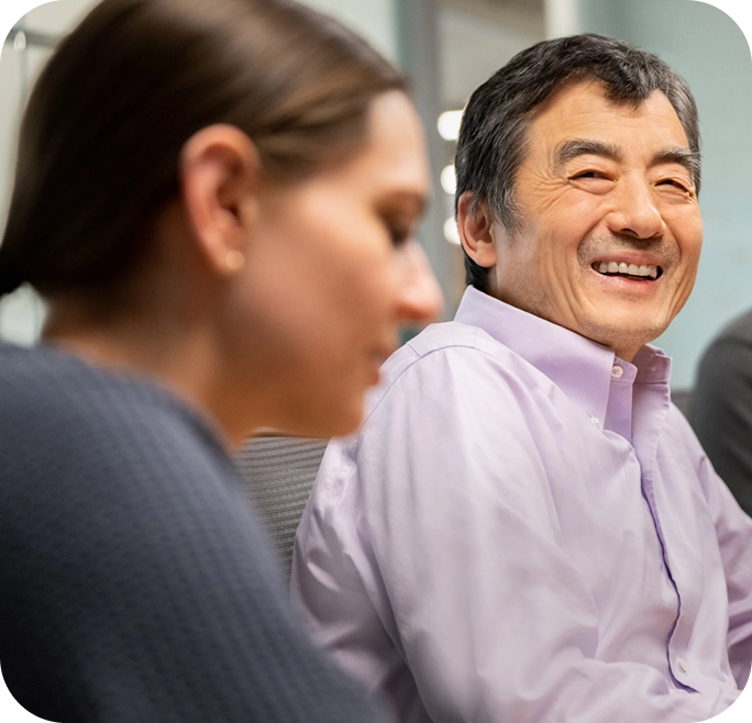 Close up shot of two Mariana Oncology employees smiling and conversing