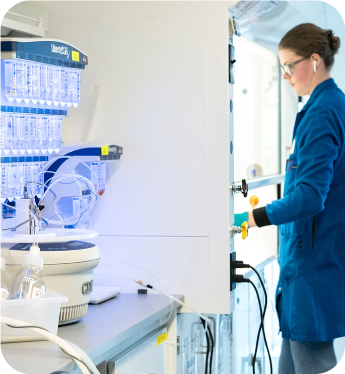 Mariana Oncology scientist in a blue lab coat works in the laboratory